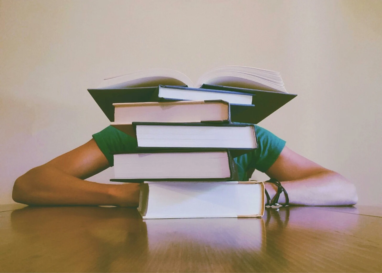 Aluno-atras-de-uma-pilha-de-livros-cansado-de-fazer-o-projeto-de-extensao-