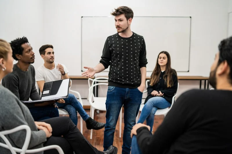 Universitário dando reforço escolar na comunidade escolar para seu projeto de extensão.
