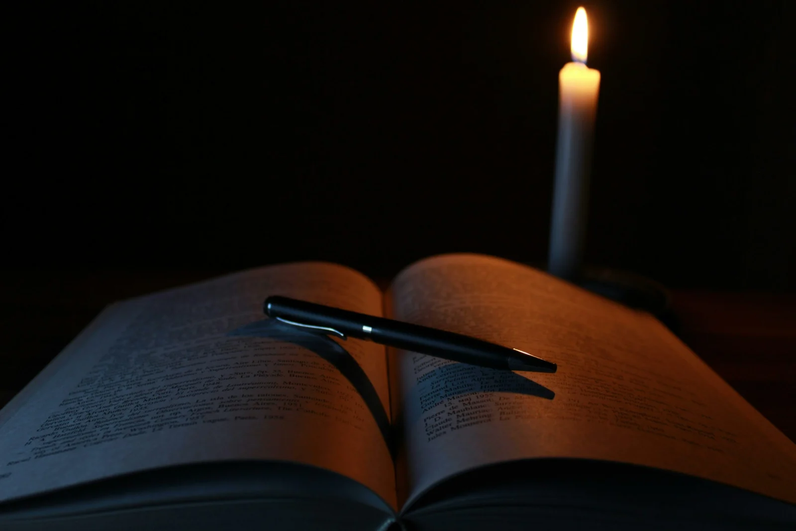 Imagem de um manual com uma cantea e a luz de vela de umaluno fazendo seu projeto de extensão Unopar